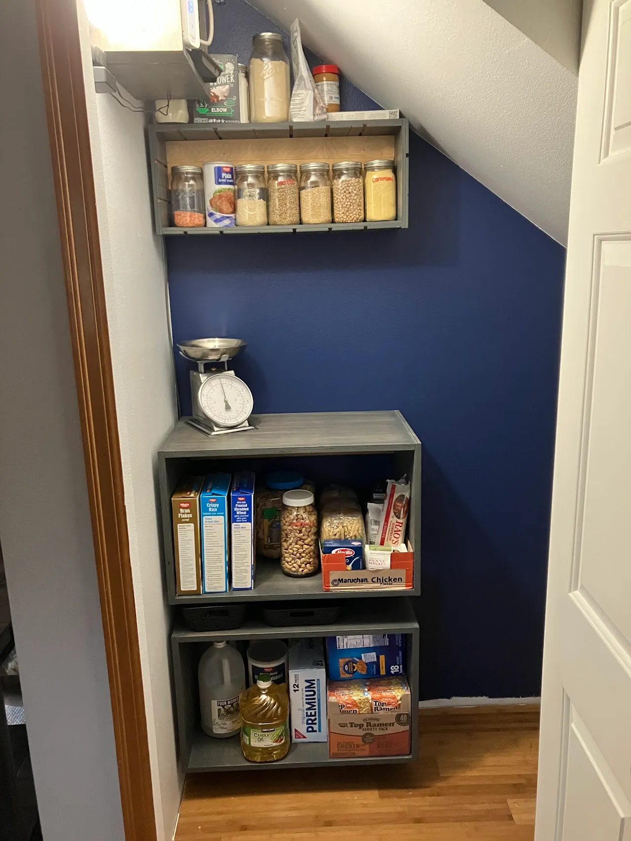 very useful built-in pantry shelving with a fresh coat of dark blue paint behind it